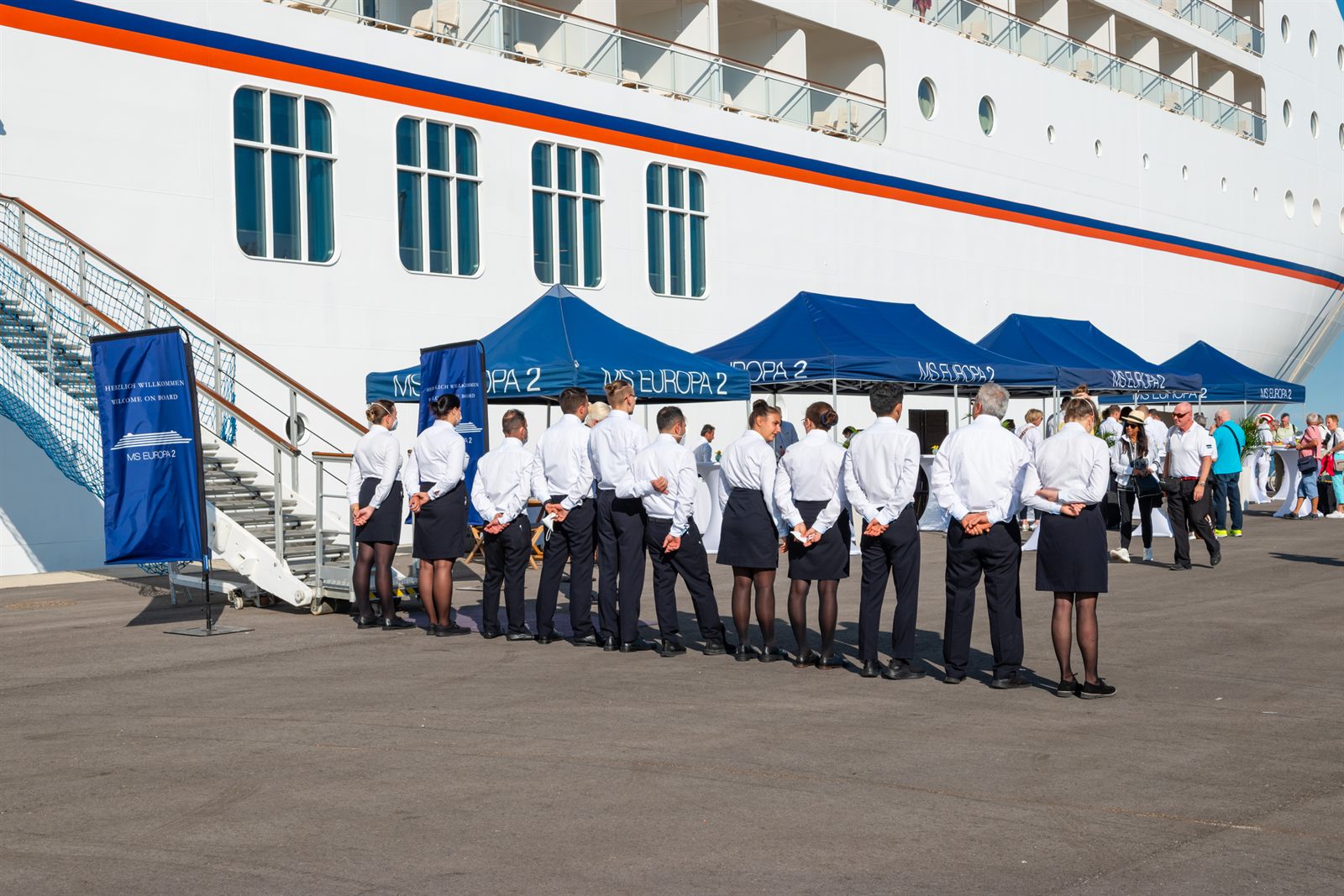 Ship crew in uniform lined up beside the gangway at a cruise pier